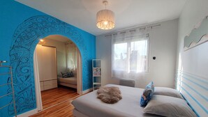 Quarto com cama, guarda-roupa, radiador e janela.