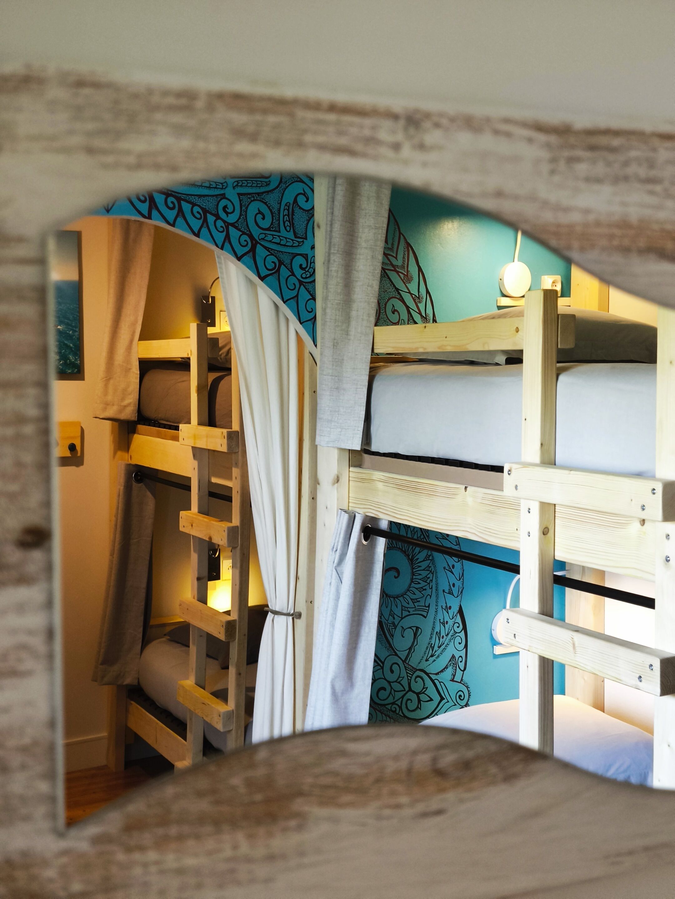 A bunk bed room with a blue wall and a wooden headboard.