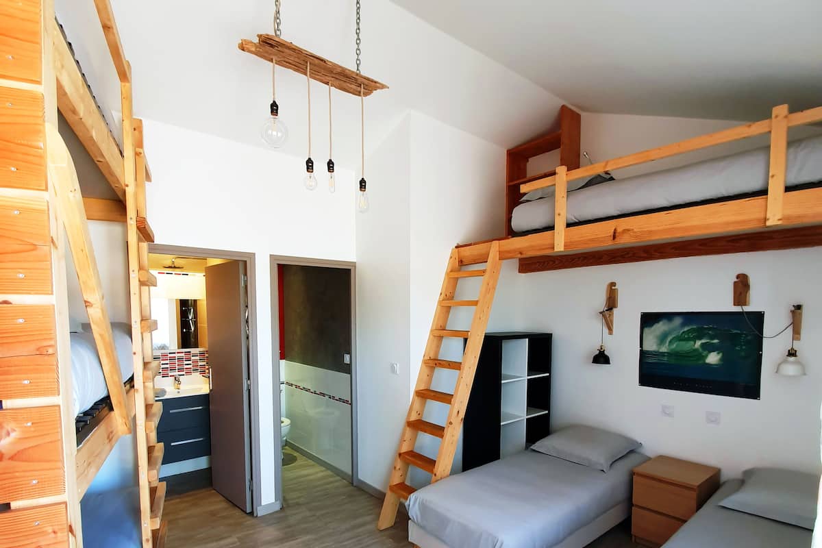 Una habitación con literas, un escritorio y un televisor.