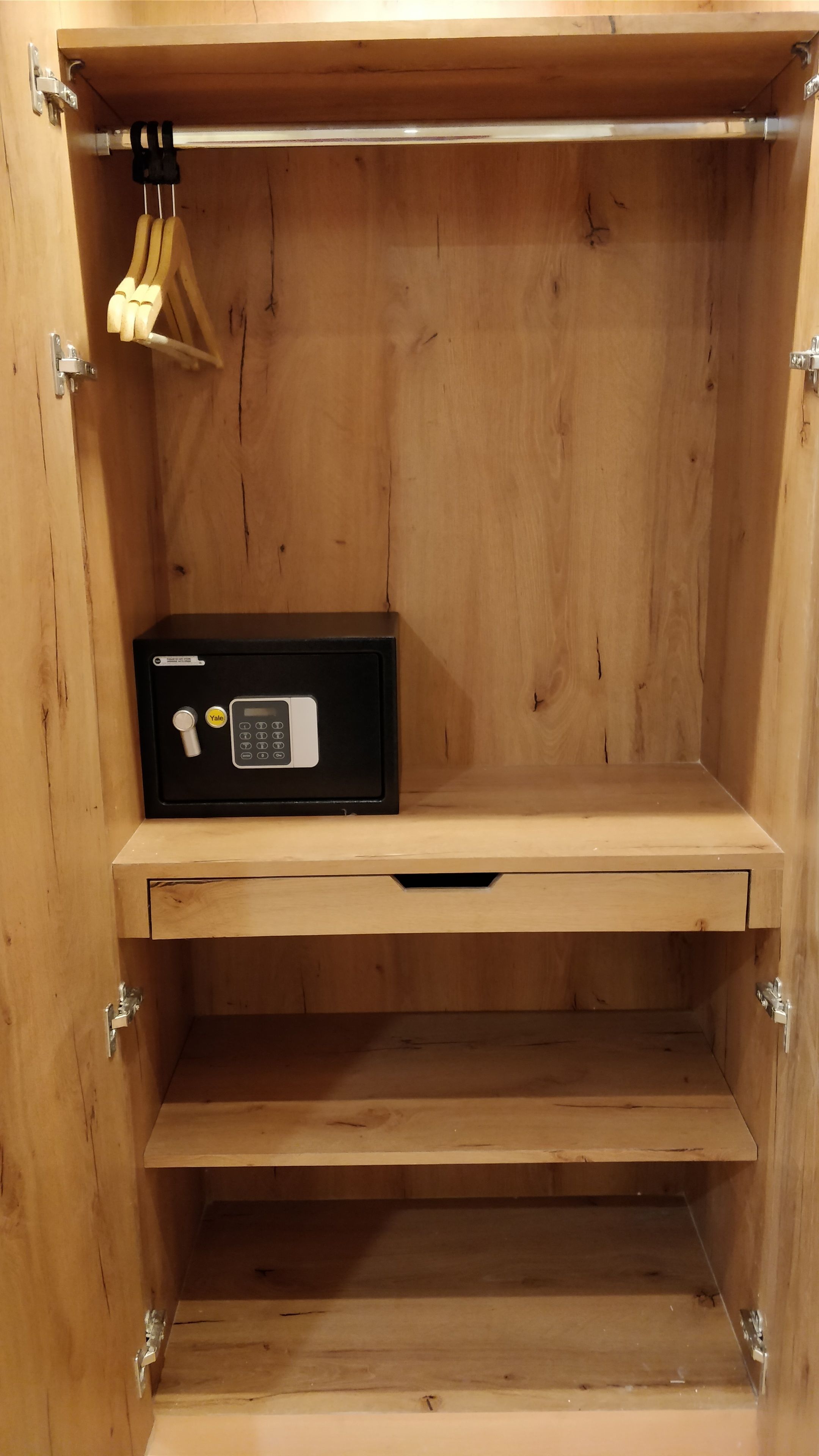 A wooden cabinet with a Yale combination lock safe, a drawer, and a hanging hook.