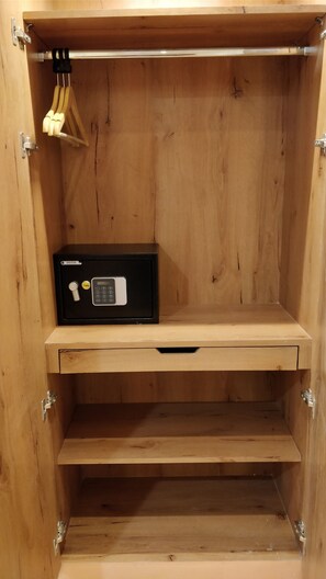 Un meuble en bois contenant un coffre-fort à combinaison de marque Yale, un tiroir et un crochet pour suspendre des objets.