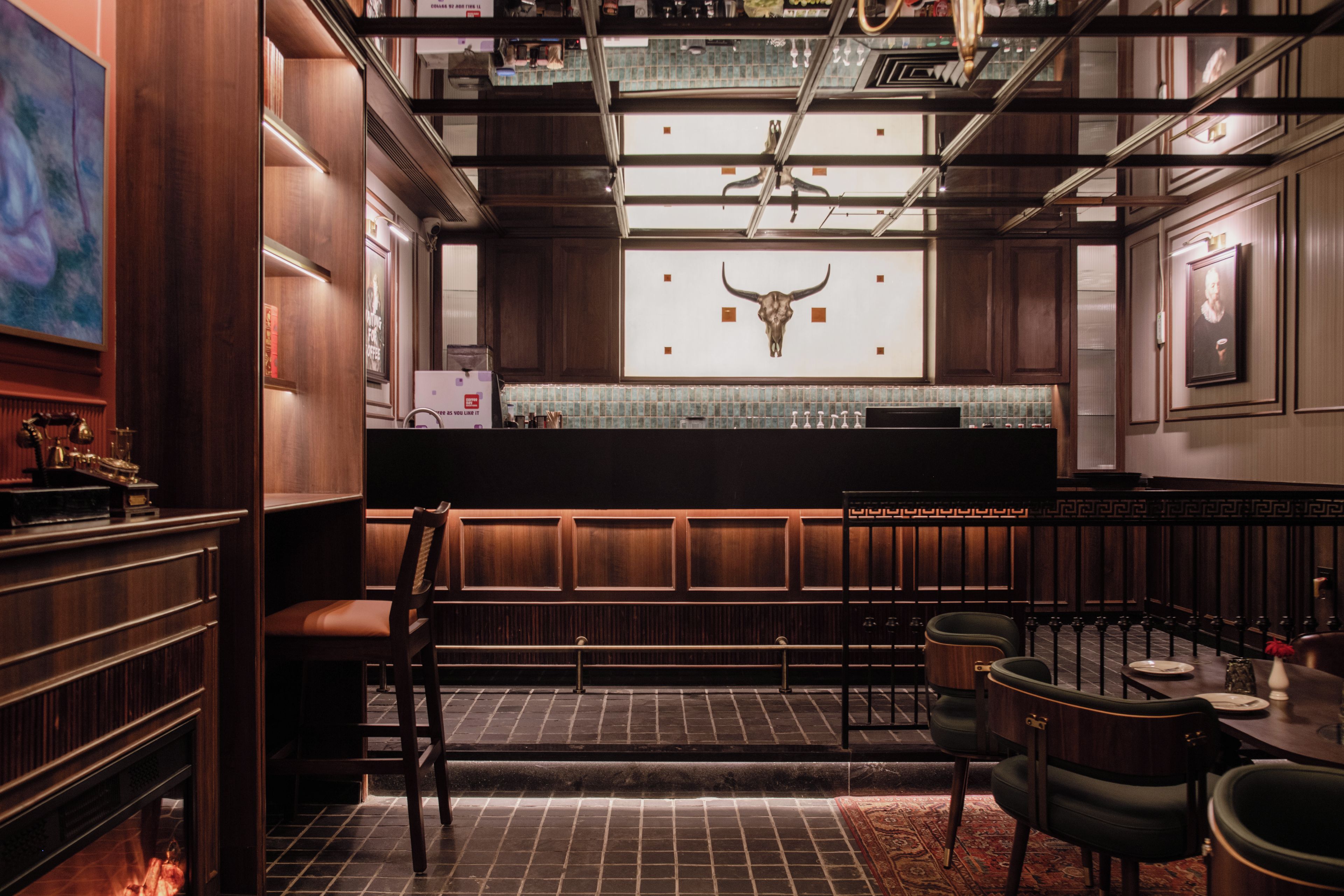 Una zona de bar con paneles de madera, un adorno en la pared con un cráneo de toro y un salpicadero de azulejos.