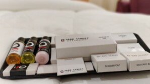 Un plateau contenant des articles de toilette, notamment du shampoing, de l’après-shampoing et un kit de rasage.
