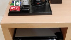 Une petite cuisine équipée d’une machine à café, de sachets de sucre et d’une boîte de mouchoirs posée sur le plan de travail.