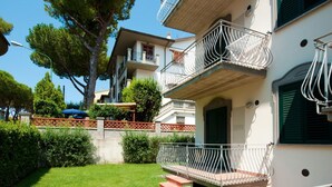A two-story building with balconies, a small garden, and a clear sky. - I Pungenti (Rosignano Marittimo)