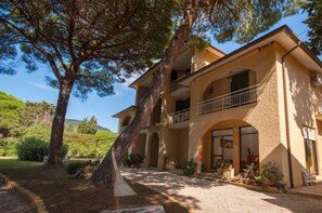 Traditional architecture meets serene surroundings in this charming building, featuring a balcony and beautifully maintained garden.