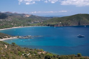 Enjoy breathtaking views of a serene bay area with boats anchored in the calm waters.