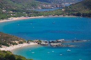 A coastal area with a beach, boats, and rocky outcrops. - Residence Golfo Della Lacona (Capoliveri)