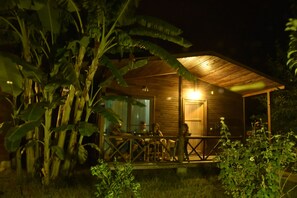 A wooden cabin with a porch, surrounded by lush vegetation. - Serenity Bungalows (Kemer)