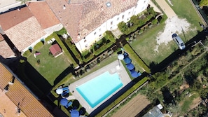 An aerial view of a residential area with a swimming pool, a tennis court, and a garden. - Residence Giuly Rosselmini (Santa Luce)