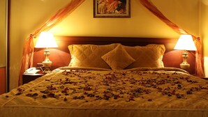 Un lit à baldaquin, deux lampes de chevet et un tableau au-dessus.