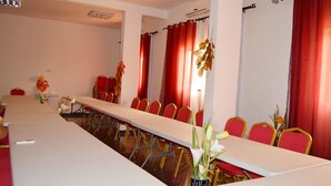 A conference room with a long table, red chairs, and a whiteboard. - Hôtel Saint-Jean (Cotonou)