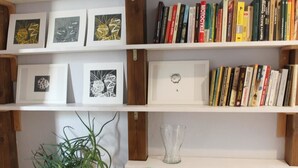 A bookshelf with framed artworks and books. - Noctis Apartment Chmielna (Warsaw)