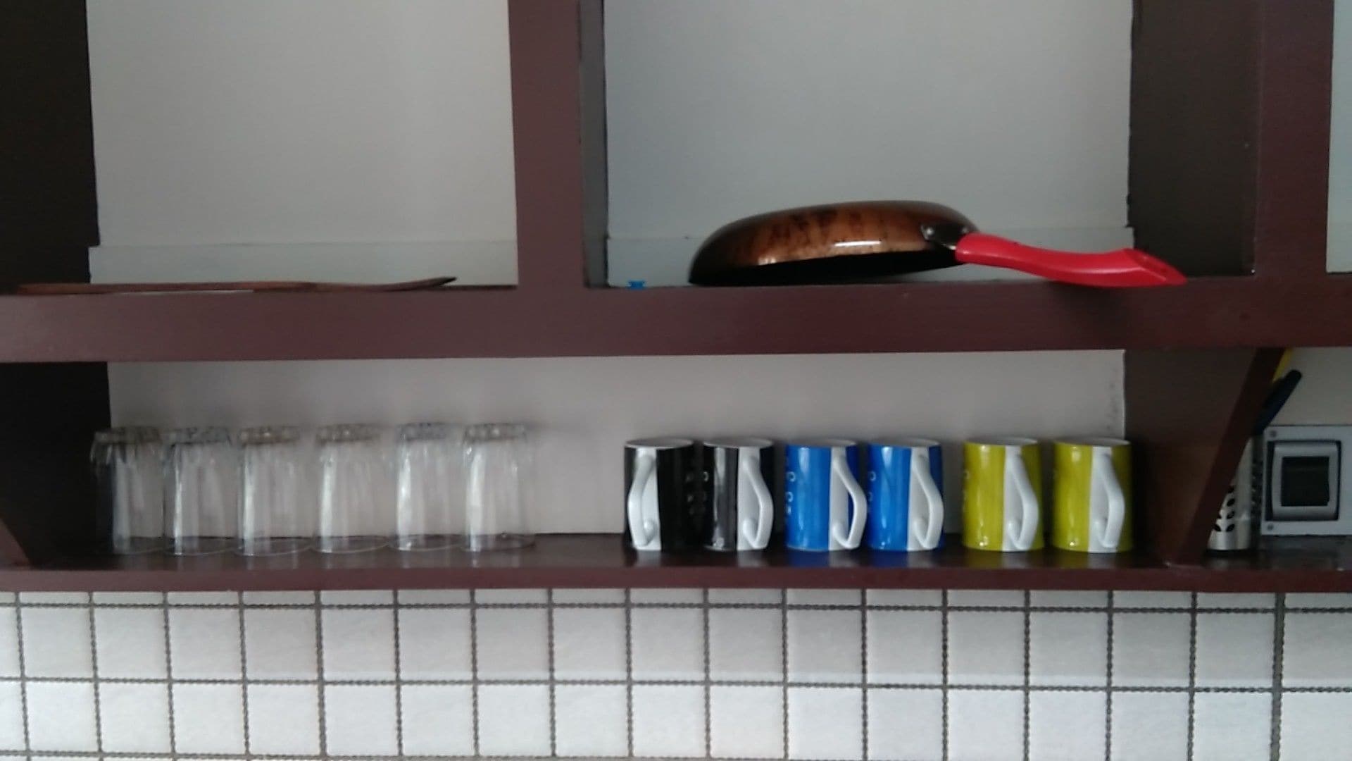 Una estantería de cocina con diversos utensilios.