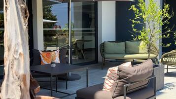 Un espace extérieur aménagé avec une table, des chaises et un grand parasol.