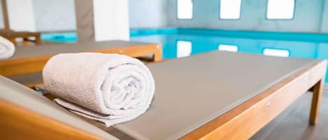 Una piscina techada, sillones reclinables de piscina