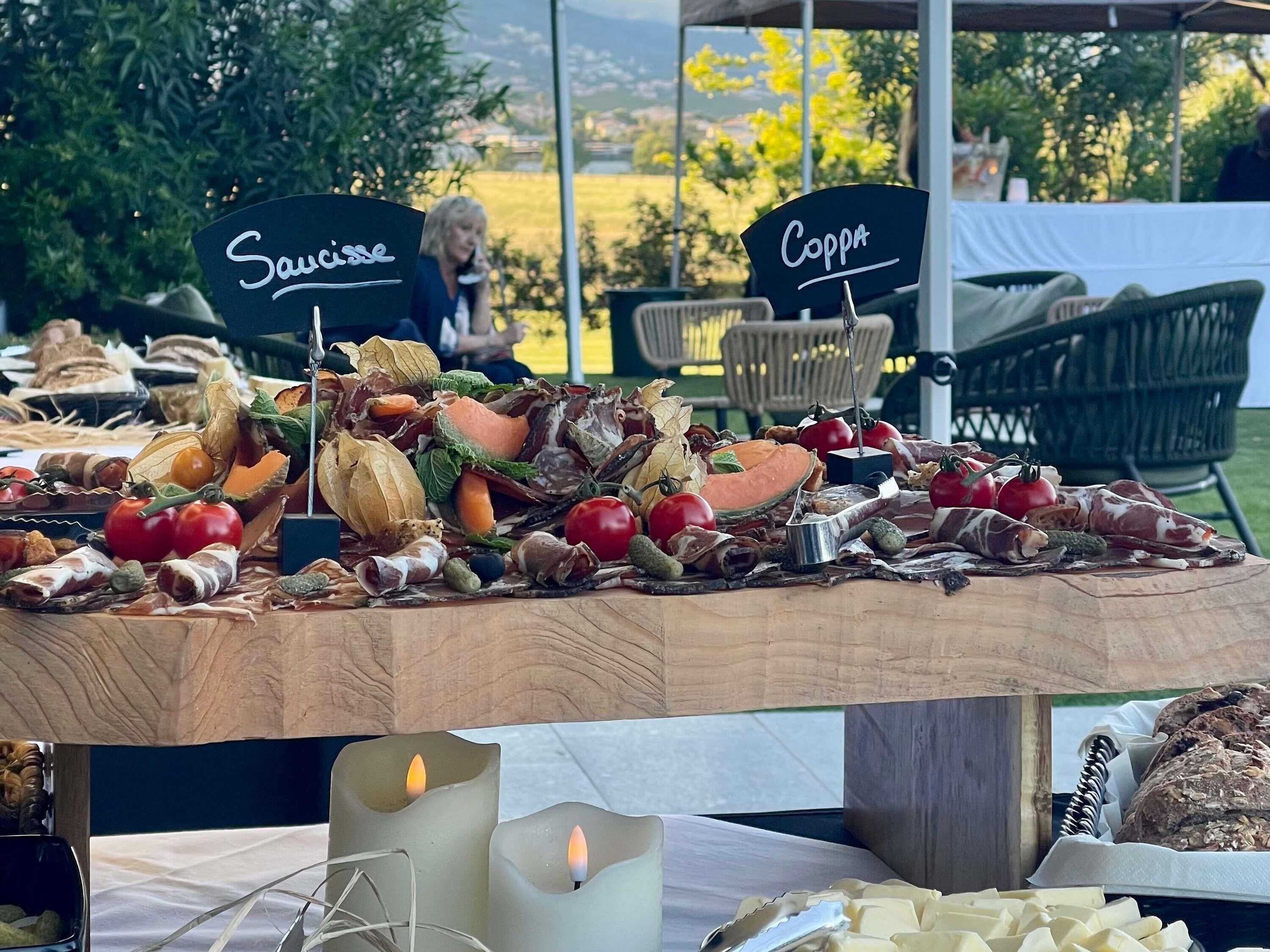 A food display table with labels 'Sauce' and 'Coppa' and a candle centerpiece.