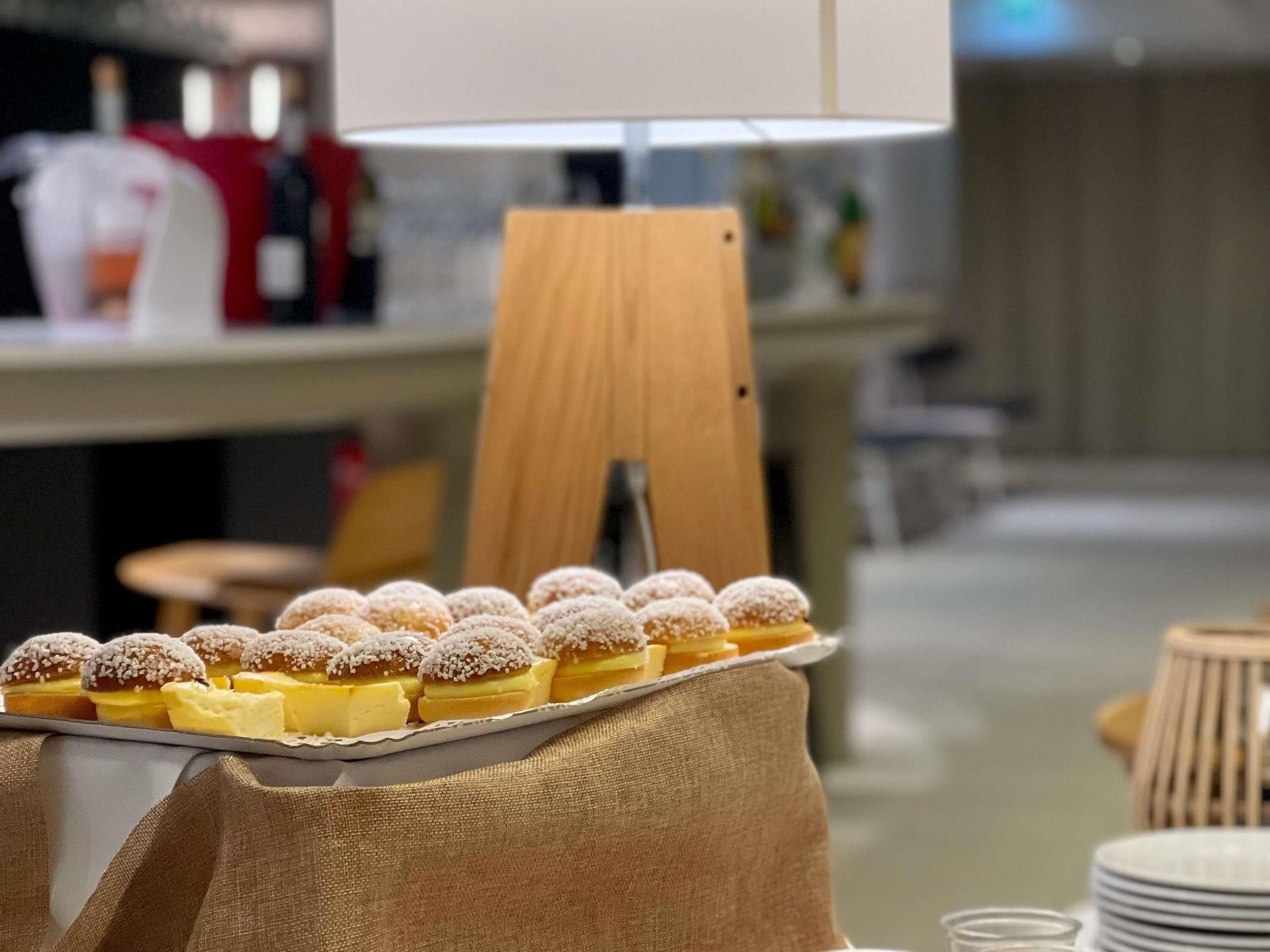 Et fad med kager på et bord, med en lampe i baggrunden.