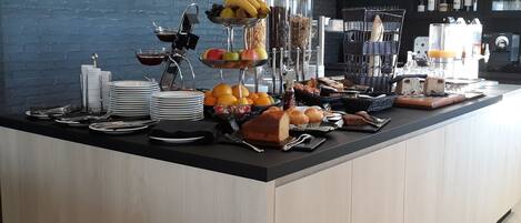 A buffet setup with various food items and utensils.