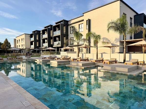 Ein modernes Hotel mit Schwimmbad, Lounges und Außenbereich.