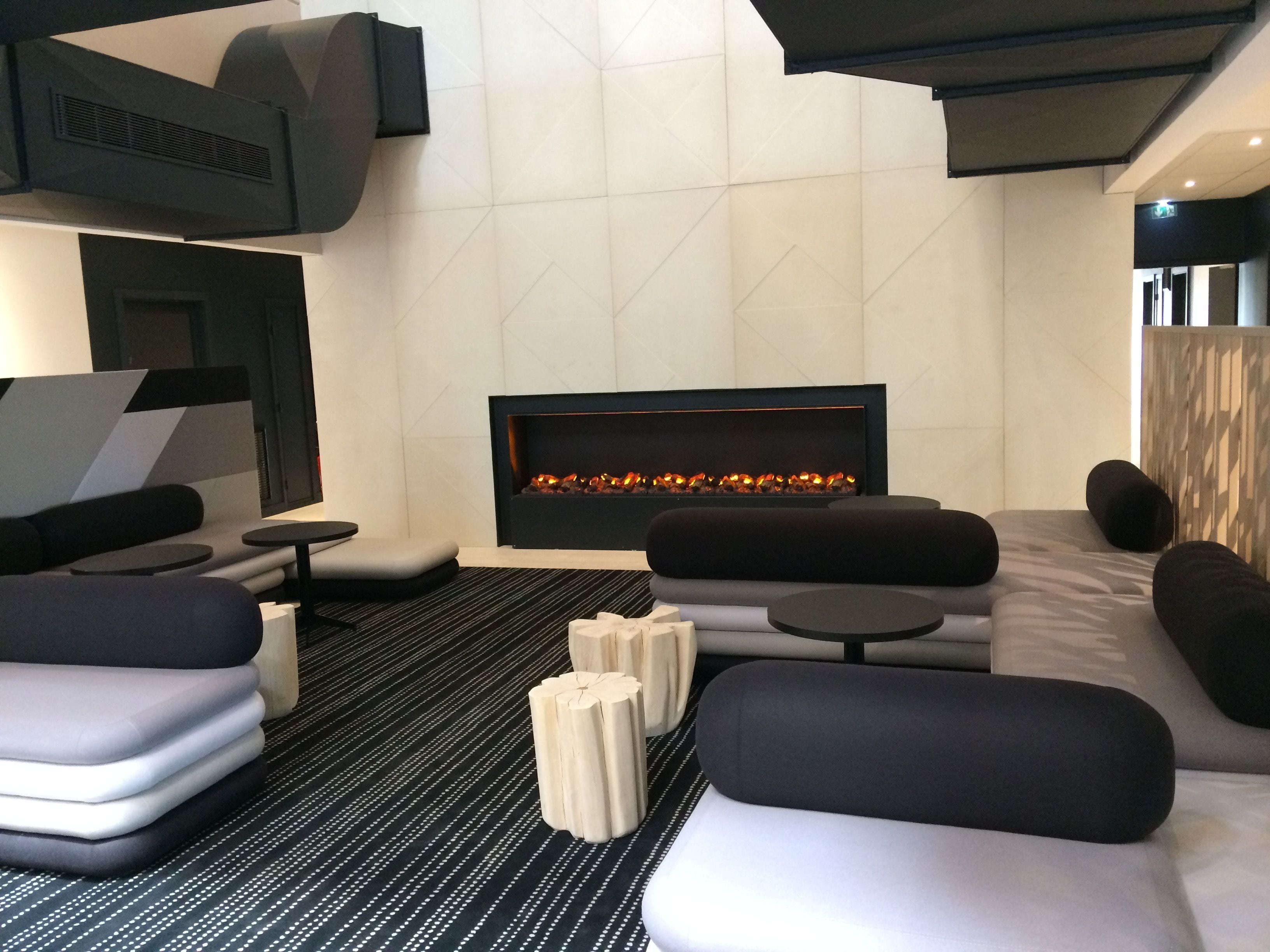 A modern lounge area with a fireplace, sofas, and a coffee table.