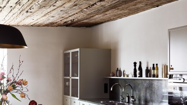 A modern kitchen with white cabinets, a black countertop, and a wooden ceiling. - Boutique Hotel Zum Oberjäger (Lackenbach)