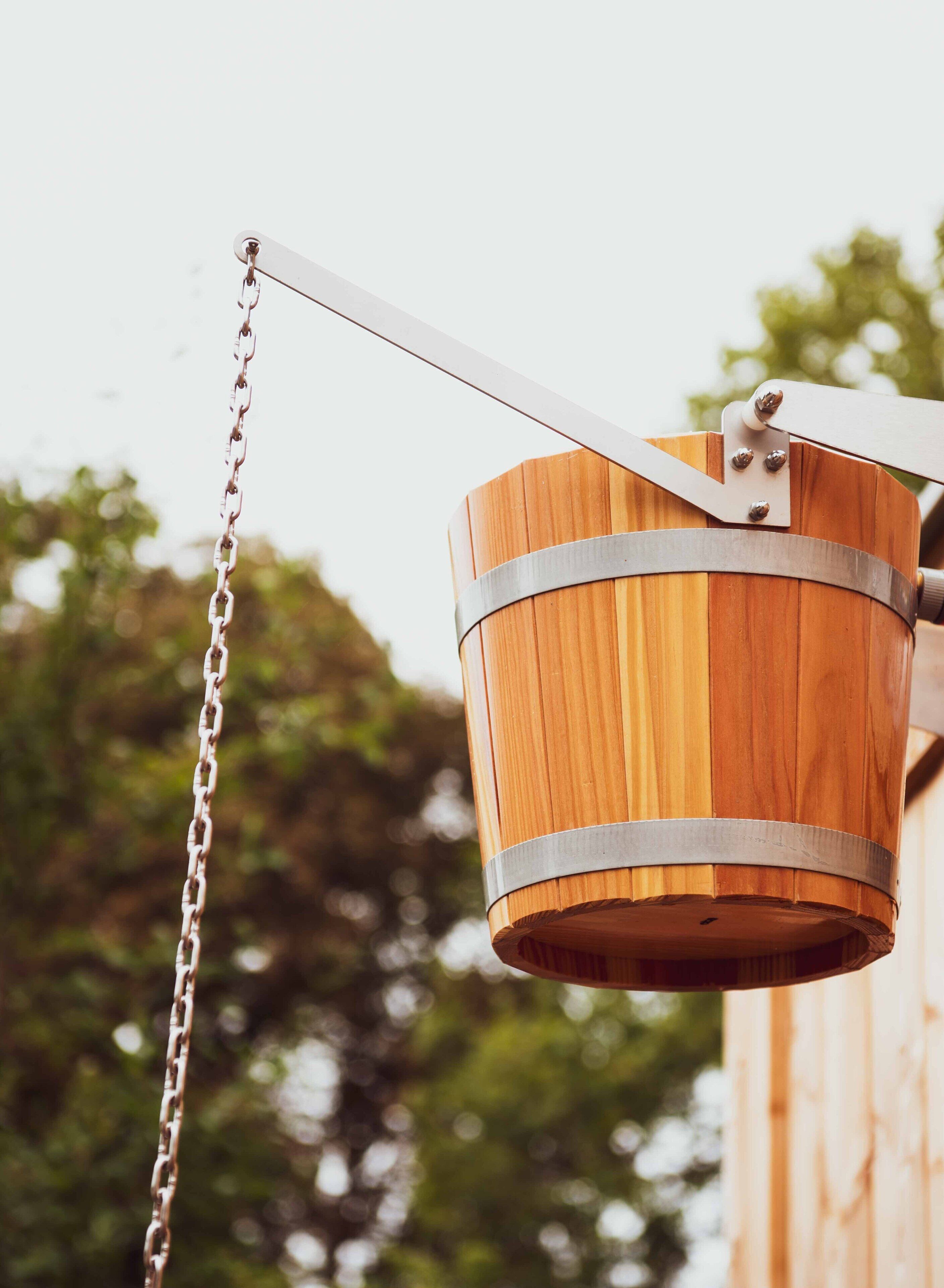 Un columpio de madera con cadena metálica y sistema de poleas.