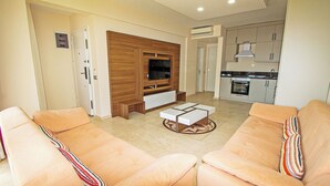 Una sala de estar con dos sofás, una mesa de centro y un televisor.