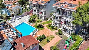 Un edificio residencial con varios balcones, piscina y paneles solares.