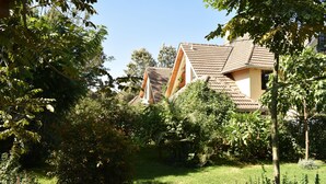 A residential area with houses featuring sloped roofs and surrounded by lush greenery. - Hob House (Nairobi)