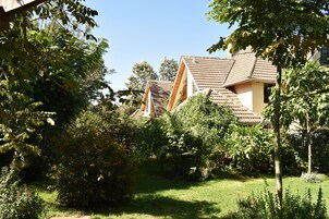 A residential area with houses featuring sloped roofs and surrounded by lush greenery.
