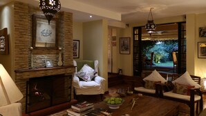 A cozy living room with a fireplace, comfortable seating, and a view of the outdoors. - Hob House (Nairobi)