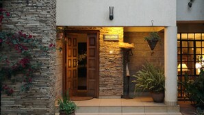 A house with a stone facade, a wooden door, and potted plants. - Hob House (Nairobi)