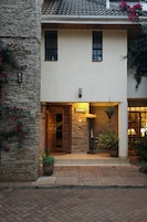 A house with a stone facade, a wooden door, and potted plants.