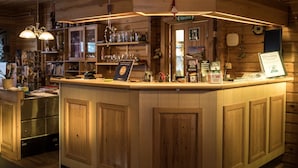 Een houten bar met een toonbank, planken met glazen en een bord waarop een beoordeling van 3,3 staat.