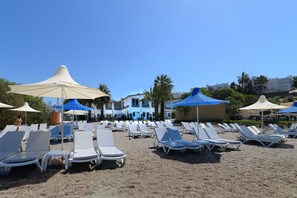 En la playa, camastros y sombrillas