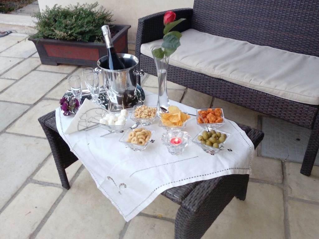 Et bord dækket udendørs med champagne, glas og diverse snacks.