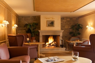 Una habitación acogedora con sillones de cuero, chimenea y un tablero de ajedrez.