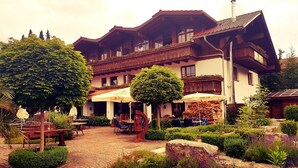 A traditional chalet with outdoor seating and a garden. - Allgäuer Kräuteralm (Oberstaufen)