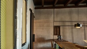 A dining area with a wooden table, chairs, and a hanging light fixture.