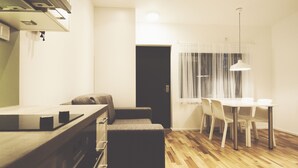 Une cuisine compacte dotée d’un plan de travail, d’un four encastré et d’un banc de couleur sombre.