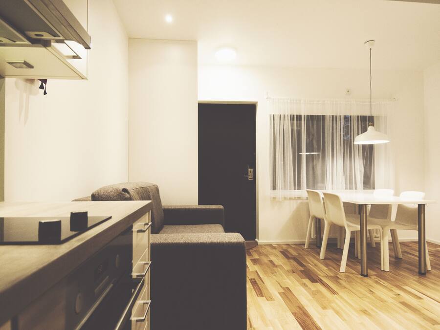 A compact kitchen with a countertop, a built-in oven, and a dark-colored bench.