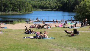 Un parc au bord du lac, doté de pelouses, de tables de pique-nique et d’une jetée qui s’avance sur l’eau.