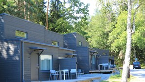 Une rangée de cabines modernes et compactes, dotées d’un espace extérieur aménagé et d’une allée en gravier.