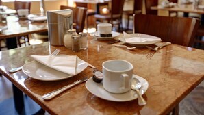 A dining table set with plates, cutlery, a cup, and a salt shaker. - Hotel Amsterdam (Hamburg)