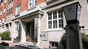 A hotel entrance with a sign indicating room numbers and amenities. - Hotel Amsterdam (Hamburg)
