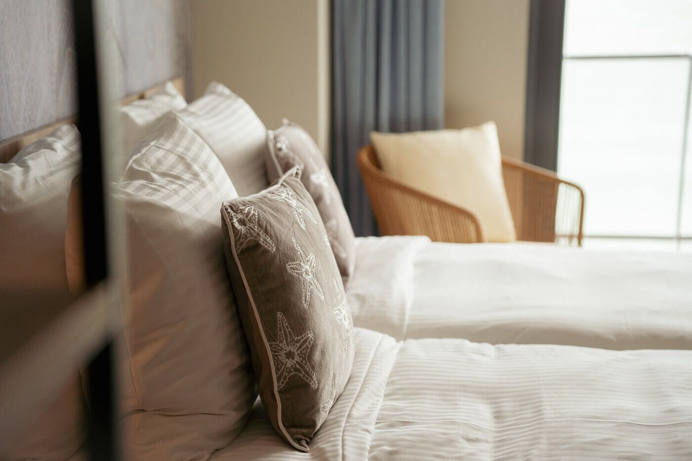 Ein Hotelzimmer mit Bett, Kissen und einem Sessel.