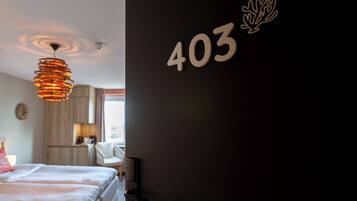 A hotel room with a bed, a desk, a chair, and a wall-mounted number '403'.
