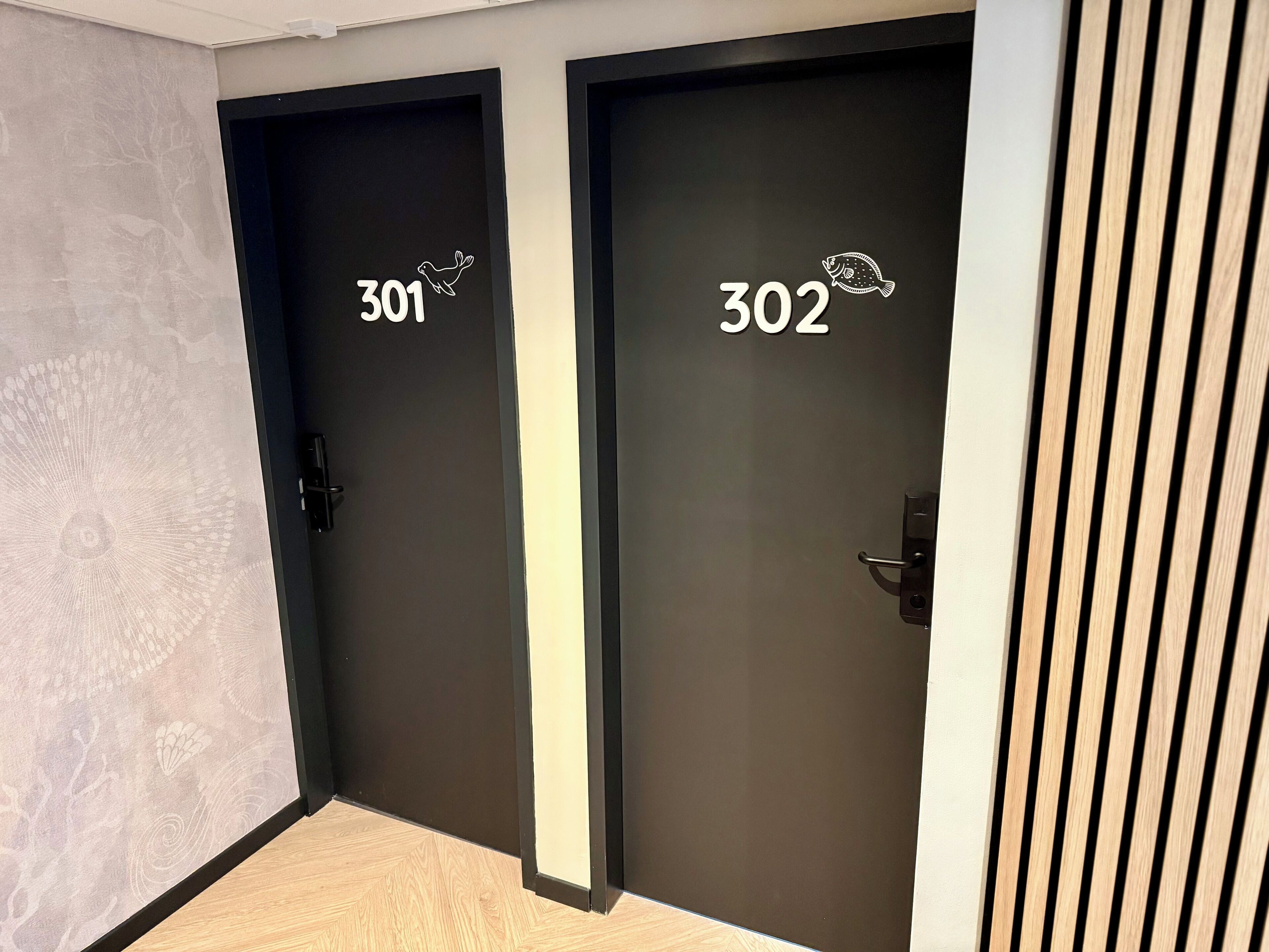 Dos puertas con las etiquetas 301 y 302, diseño minimalista y un pequeño icono de pez sobre cada número.