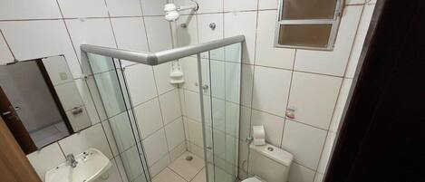 A bathroom with a glass shower enclosure, a sink, a toilet, and a mirror.
